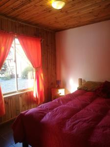 a bedroom with a bed and a window at Cabañas Tu Bosque in Isla Negra