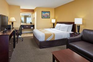 une chambre d'hôtel avec un lit, un canapé et une télévision dans l'établissement Comfort Inn Encinitas Near Legoland, à Encinitas