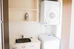 a small kitchen with a sink and a washing machine at Wyndham Resort Torquay in Torquay