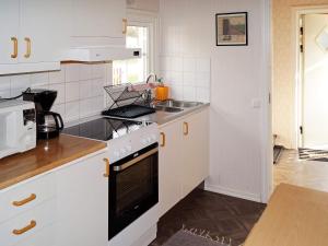 a kitchen with white cabinets and a stove top oven at One-Bedroom Holiday home in Hjältevad in Svenstorp