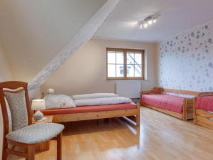 キュールングスボルンにあるQuaint Apartment in Kuhlungsborn with Gardenのベッドルーム1室(ベッド2台、椅子、窓付)