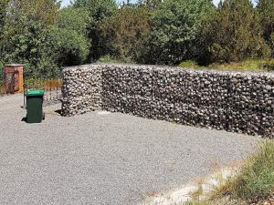 a stone wall with a trash can next to it at Luxury Holiday Home in R m with Jacuzzi in Kongsmark