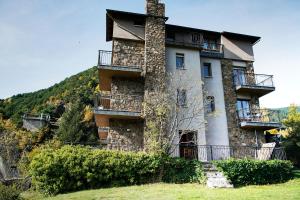 - un grand bâtiment en pierre avec balcon sur une colline dans l'établissement Hotel La Burna Panoràmic, à Sispony