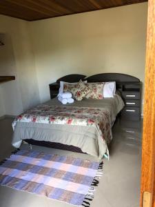 ein Schlafzimmer mit einem Bett mit zwei Handtüchern darauf in der Unterkunft Chalé D'avilas in Monte Verde