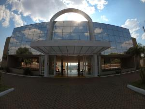 a large glass building with the sun in the sky at Hotel Manacá in Sacramento