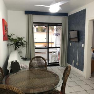d'une salle à manger avec une table, des chaises et une fenêtre. dans l'établissement Apartamento Praia dos Ingleses, à Florianópolis