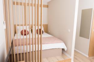 een slaapkamer met een wieg met 2 kussens op een bed bij Urban Residence Apartments in Mostar