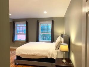 Un dormitorio con una cama y dos ventanas. en Alina & Fanny - Philadelphia 1212 Mt Vernon St, en Filadelfia