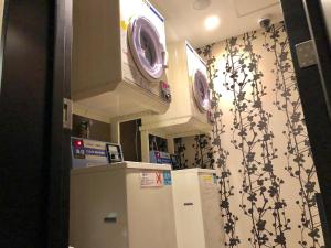 a kitchen with a refrigerator and a wall at APA Hotel Nambaminami Ebisucho Eki Shinsekai in Osaka