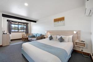 ローンセストンにあるOlde Tudor Hotelのベッドルーム(大型ベッド1台付)、リビングルームが備わります。