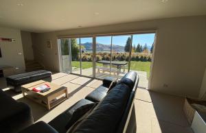 a living room with a couch and a table at The Barn in Lake Tekapo