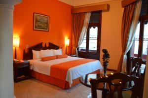 a bedroom with a bed with an orange wall at Hotel Royal Palace in Guatemala