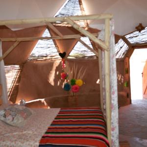 a bedroom with a bed with a wooden frame at Domo del desierto in San Pedro de Atacama
