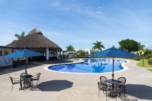 a pool at the resort with chairs and umbrellas at Casa STB01 con Alberca a 5 min de Nuevo Vallarta in Mezcales