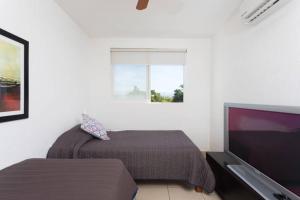 a bedroom with a bed and a flat screen tv at Casa STB01 con Alberca a 5 min de Nuevo Vallarta in Mezcales