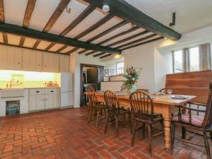 a kitchen and dining room with a wooden table and chairs at Hole Farm in Gidleigh