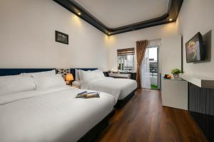 a hotel room with two beds and a kitchen at Diamond Nostalgia Hotel & Spa in Hanoi