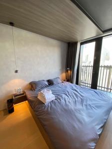 1 dormitorio con cama azul y ventana en SPATIUM Tokyo, en Tokio