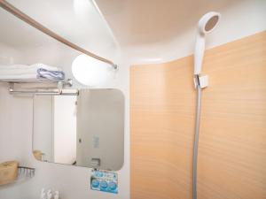 een badkamer met een douche en een spiegel bij Super Hotel JR Fujiekimae Kinenkan in Fuji