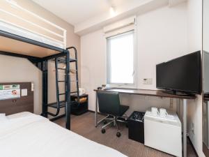 een slaapkamer met een stapelbed en een bureau met een computer bij Super Hotel JR Fujiekimae Kinenkan in Fuji