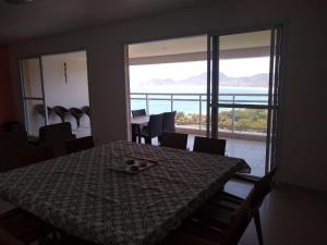 a dining room with a table and a view of the ocean at Vista para o mar in Guarujá