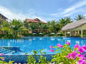 a swimming pool at a resort with pink flowers at Pandanus Resort in Mui Ne