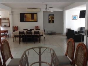a dining room and living room with a table and chairs at Casa Bocoyna in Acapulco