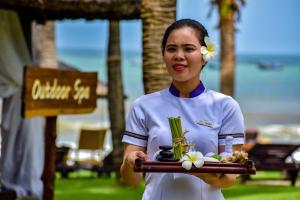 a woman holding a tray of food in her hands at Pandanus Resort in Mui Ne