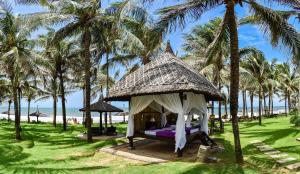 a gazebo on the beach with palm trees at Pandanus Resort in Mui Ne