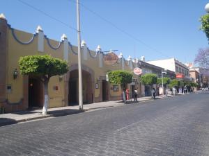 a cobblestone street in a town with a building at Hotel Casa Real Tehuacan in Tehuacán