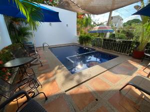 einen Pool mit einem Tisch, Stühlen und einem Sonnenschirm in der Unterkunft Chacala Caracoles 6 pax AA con ALBERCA y PLAYA a 50 mts in Chacala
