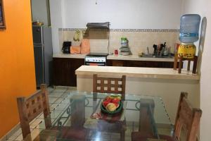 eine Küche mit einem Glastisch und einer Obstschale in der Unterkunft Chacala Caracoles 6 pax AA con ALBERCA y PLAYA a 50 mts in Chacala