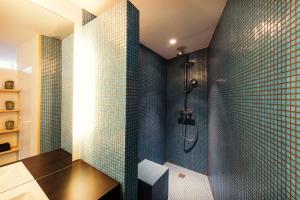 a bathroom with a shower with blue tiles at Studio 17 in Ghent +23 photos