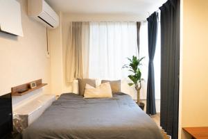 東京にあるHigashi Shinagawa Apartmentのベッドと大きな窓のある寝室