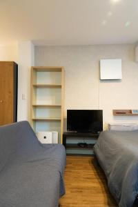 1 dormitorio con 2 camas y TV de pantalla plana en Higashi Shinagawa Apartment, en Tokio