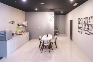 een keuken met een tafel en stoelen in een kamer bij Spacious 3 Bedrooms by Cozy Home in Bayan Lepas