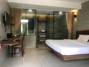 Schlafzimmer mit einem Bett, einem Schreibtisch und einer Dusche in der Unterkunft BK Hotel in Phnom Penh