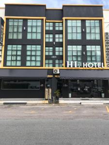um hotel com um edifício preto e amarelo em HL HOTEL Kota Bharu em Kota Bharu