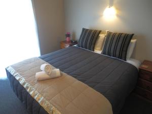 a bedroom with a large bed with a towel on it at Lake Wanaka Lodge in Wanaka