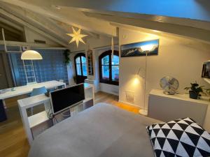 Una sala de estar con televisión y un comedor. en Mansarda Del Sole, Nel Cuore Di Aosta, en Aosta