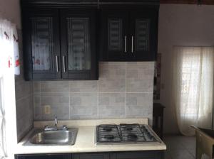 a kitchen with a sink and a stove and cabinets at Bungalow for rest at Santa Cruz in Tepic