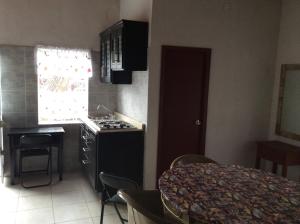 a kitchen with a stove and a sink and a table at Bungalow for rest at Santa Cruz in Tepic +2 photos