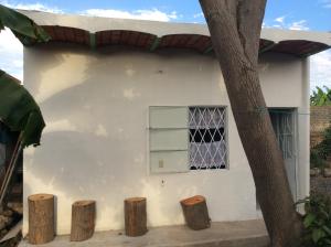 een wit huis met een raam en drie boomstronken bij Casa de descanso en Santa Cruz in Tepic