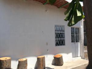 een wit gebouw met drie boomstronken ervoor bij Casa de descanso en Santa Cruz in Tepic