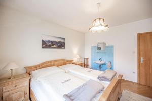 um quarto com uma cama grande e lençóis brancos em NaturparkResort Apartment Hörmann em Ardning