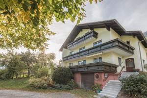 ein gelbes und rosafarbenes Haus mit einer Treppe davor in der Unterkunft NaturparkResort Apartment Hörmann in Ardning