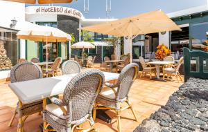 an outdoor patio with tables and chairs and umbrellas at El Hotelito Del Golfo in El Golfo