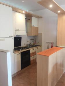 uma cozinha com armários brancos e um forno com placa de fogão em Estella Mare em Letojanni