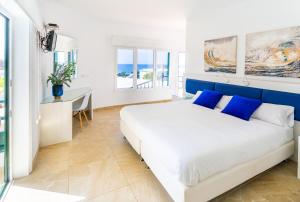 a white and blue bedroom with a bed and a desk at El Hotelito Del Golfo in El Golfo