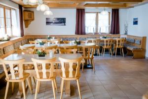 - un restaurant avec des tables et des chaises dans une salle dans l'établissement Hotel Bergführer, à Elm